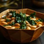 Green kale and cannellini safehouse soup in a rustic bowl with olive oil drizzle